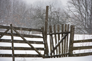 Snow is falling on a wooden fence at winter, mountain Kozomor, Serbia