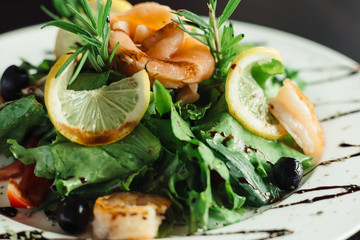 Salad with shrimp and lemon on white dish