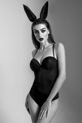 Young woman in black sexy bodysuit, black and white photo