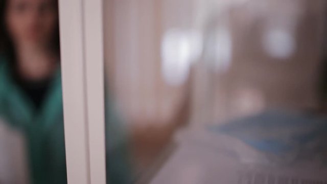 Woman doctor opens a key a glass cabinet with medicines and puts the bottle on the shelf with formalin
