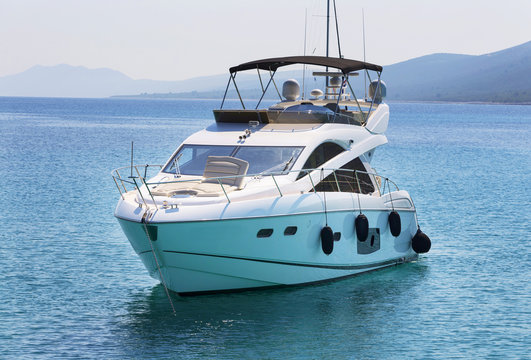 Fototapeta Luxury yacht in azure seas parked in a beautiful blue bay. Modern white Yacht in the sea around island on Croatia.