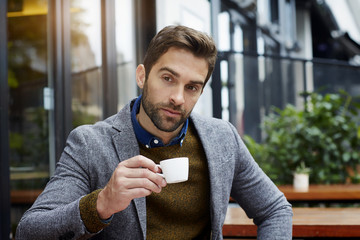 man holding coffee cup and thinking