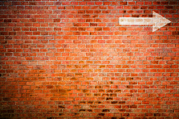 White arrow on vintage brick wall, decision making concept
