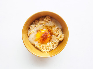 Top view bowl of instant noodle and soft egg boiled on white bac