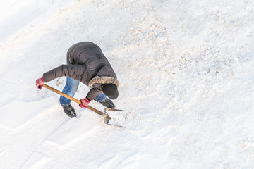 Man cleans snow shovel, top view