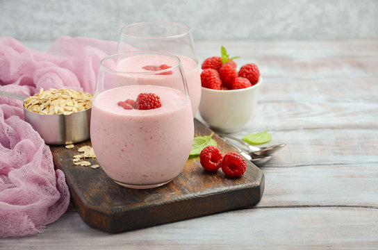 Raspberry and banana smoothie with oatmeal on the rustic wooden table, selective focus, horizontal, copy space