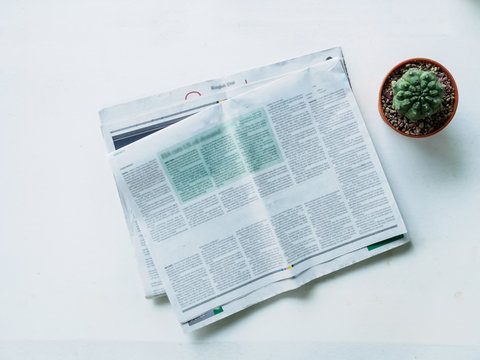 Top view stack newspaper and cactus pot on work place desk of of