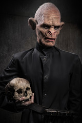 Angry baboonish man in black clothes on dark background
