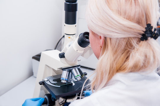 Close up Professional young female scientist doing test in laboratory with microscope with digital camera (forensics, microbiology, biochemistry, genetics, oncology) laboratory. selective focus