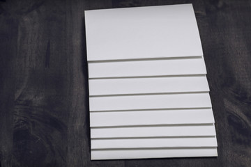blank papers stack up on wooden table.