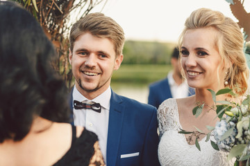 Pretty wedding couple greets their guests standing before weddin