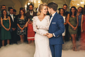 Groom holds bride's hand tender during their first dance