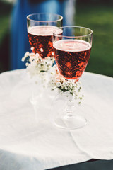 Waiter holds white tray with glasses full of red drink