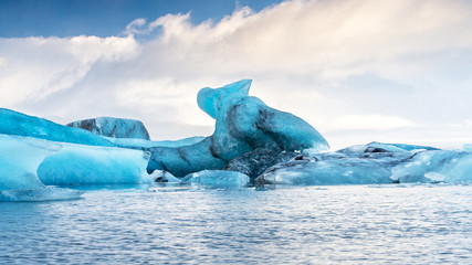 Panoramic view of blue icebergs floating on the lake, which one looks like pelican.