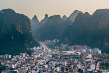 The view of the cityscape and karst rock mountains in Yangshuo, Guilin region, Guangxi Province, China.