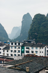The foggy view of the cityscape and karst rock mountains in Yangshuo, Guilin region, Guangxi Province, China.