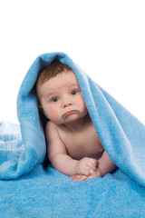 Newborn baby lying down and smiling in a blue towel