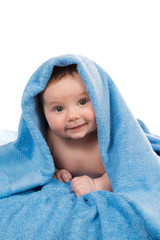 Newborn baby lying down and smiling in a blue towel