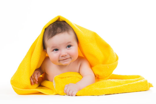 Newborn Baby Lying Down And Smiling In A Yellow Towel