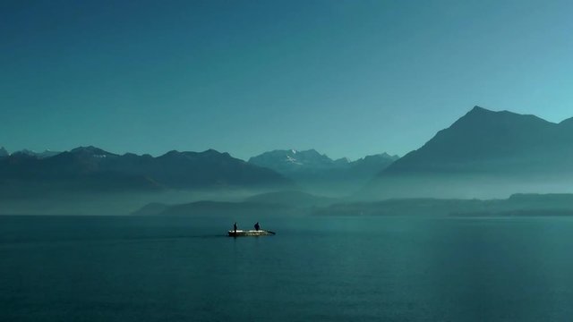 people in a small boat crossing lake thun, Thuner See