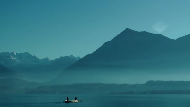 people in a small boat crossing lake thun, Thuner See