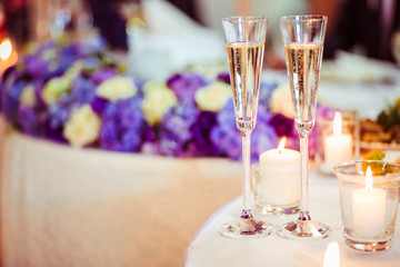 The glass of champagne stands near candles