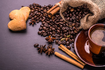 Coffee cup coffee beans and biscuits, cookies in the shape of heart on black background