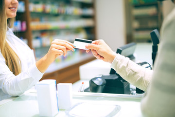 Experienced pharmacist counseling male customer in modern pharma