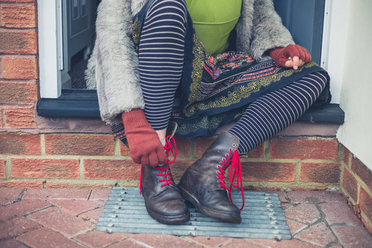 Woman tying her shoes on step outside