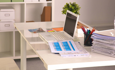 office desk with a computer and stack of papers