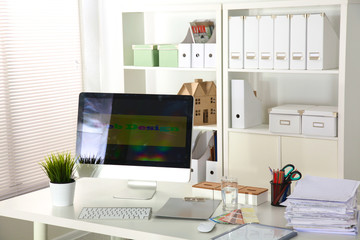 office desk with a computer and stack of papers