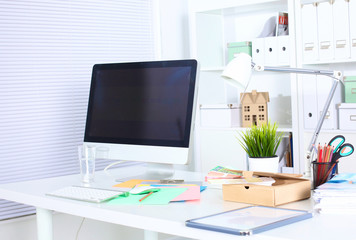 office desk with a computer and stack of papers