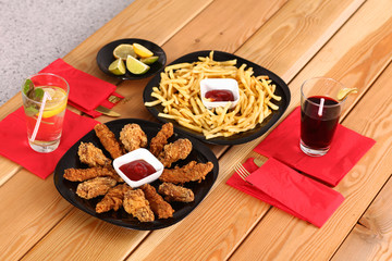 potatoes and wings with sauce in the plate on the table