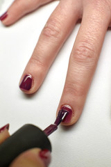 Manicure nail paint purple color.