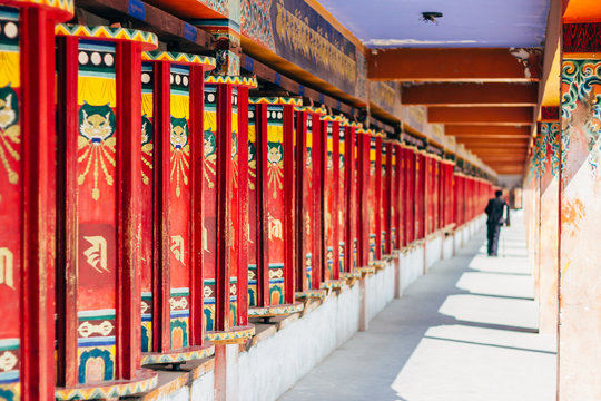 Qinghai, China - 8 October 2016: Local man in tibetan clothes - chuba spinning prayer wheels in buddhist Longwu (Rongwo) Monastery in Qinghai, China