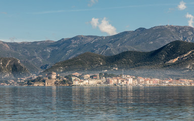 View across St Florent bay in Corsica to the town of Saint Florent with mountains behind