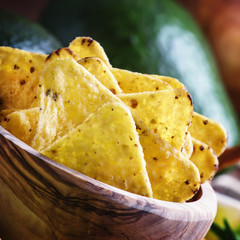 Corn nachos with salt in wooden bowl, old wooden background, sel