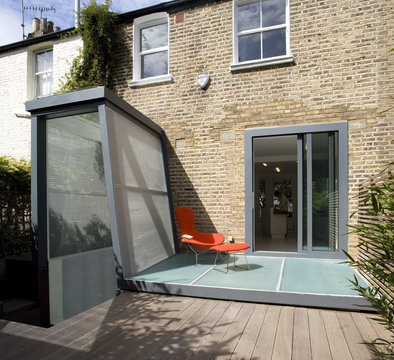 Light Refraction, London. Modern patio and decking on rear of Victorian terrace house.