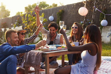 Group Of Friends Enjoying Outdoor Picnic In Garden