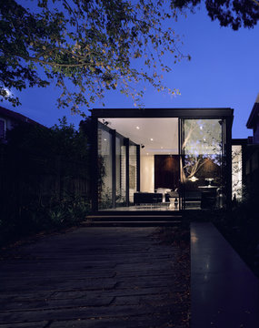 Exterior of a house seen at night with garden