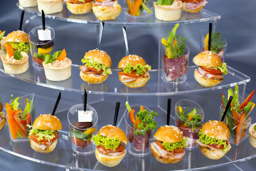 Mini desserts and meat canapes vegetable snacks in plastic cups canapes