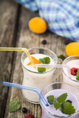 Smoothies or yogurt with fresh berries on a wooden table.