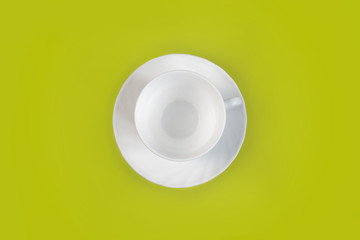 White mug and saucer on a olive background