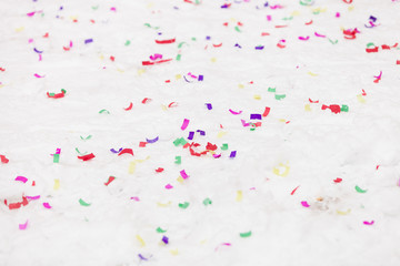 Colorful confetti on white snow outdoors. Celebration, Christmas and party concept