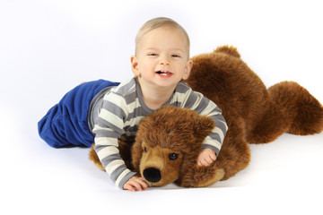 Ein kleiner Junge kuschelt mit einem Plüschbären 