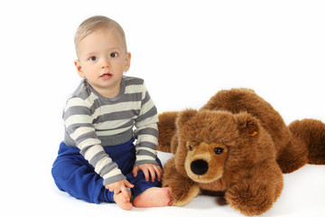 Ein kleiner Junge kuschelt mit einem Plüschbären 