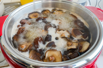 Raw home made Shiitake boiled in iron bowl.