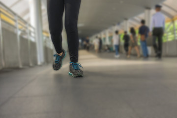 The legs of a woman wearing tight pants and running shoes joggin