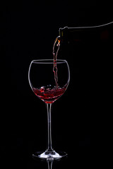 Naklejka na ściany i meble Wine glasses with wine bottle on a black background, minimalism,