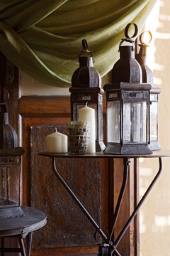 Lanterns and candles on rustic metal tables.